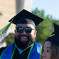 A bearded man graduating