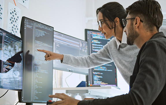 Woman points at a man's code