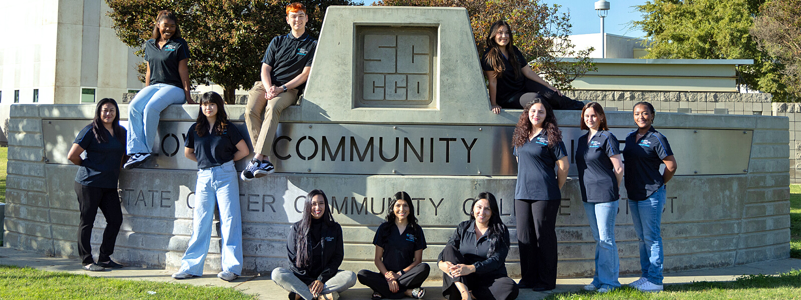 The Student Activities Team taking a photo in front of the Clovis Community College sign outdoors.