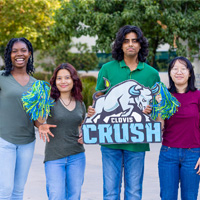 Four male and female Clovis Community College students holding a Clovis Crush sign