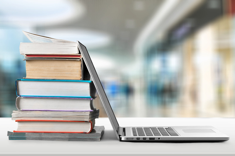 A stack of books and a laptop