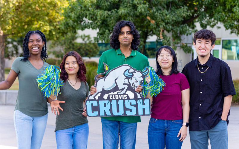 Male and female students holding up a Clovis Crush sign