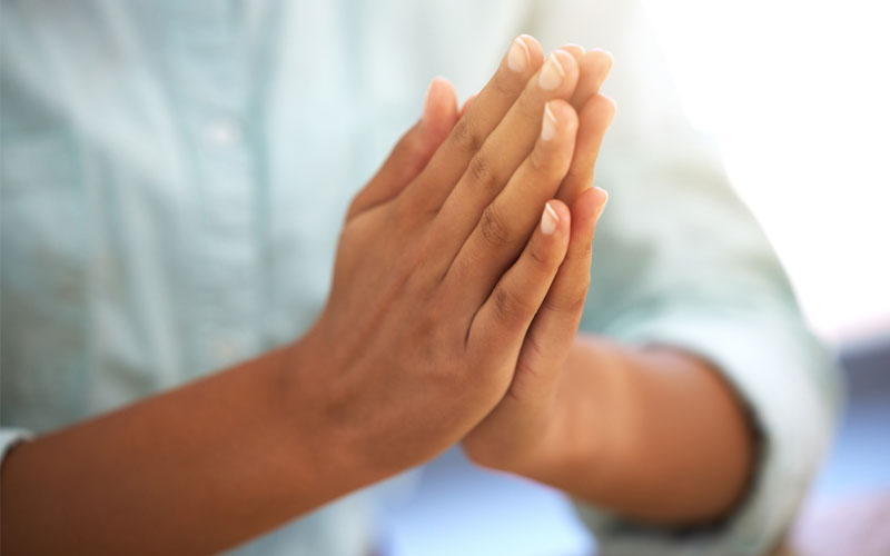 Close-up of a person's hands praying