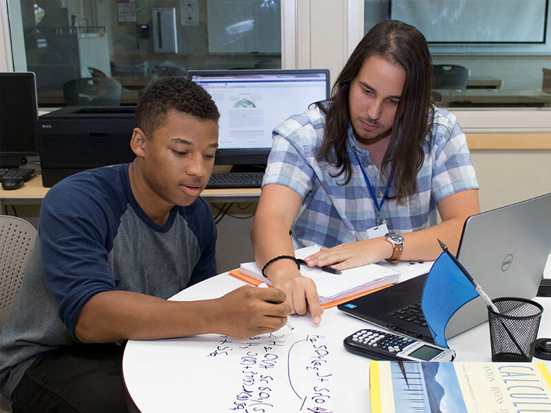 A tutor helping a male student at the Tutorial Center