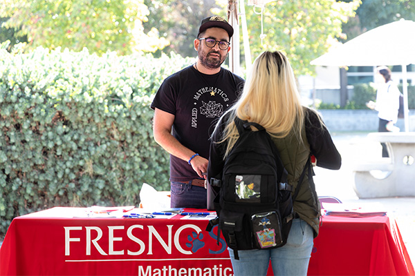 A Clovis Community College student talks with a Fresno State representative at the Transfer Day Festival