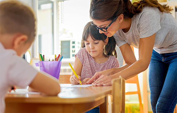 An elementary teacher helping a kid