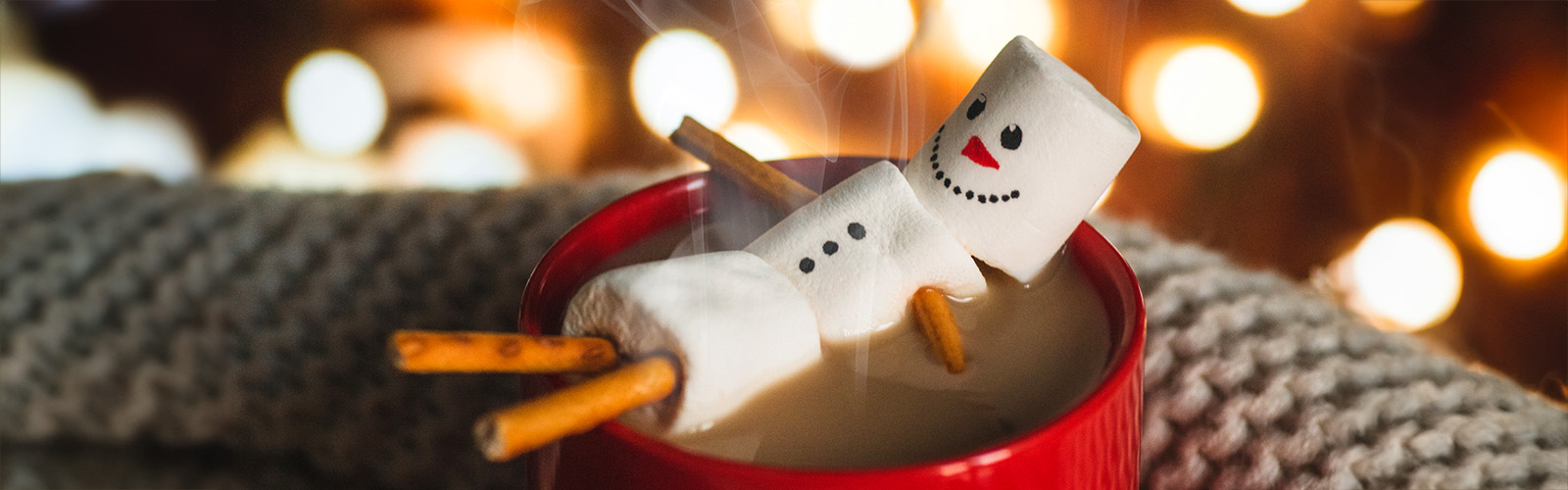 A snowman made of marshmallows relaxing in a cup of hot chocolate