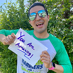 Isaac Reyna holding up a sign that says "You are Amazing!"