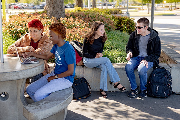 A group of students hang out in the shade